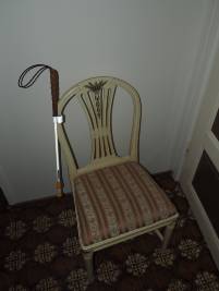 Bild på käppen fastsatt med käpphållaren på en stol